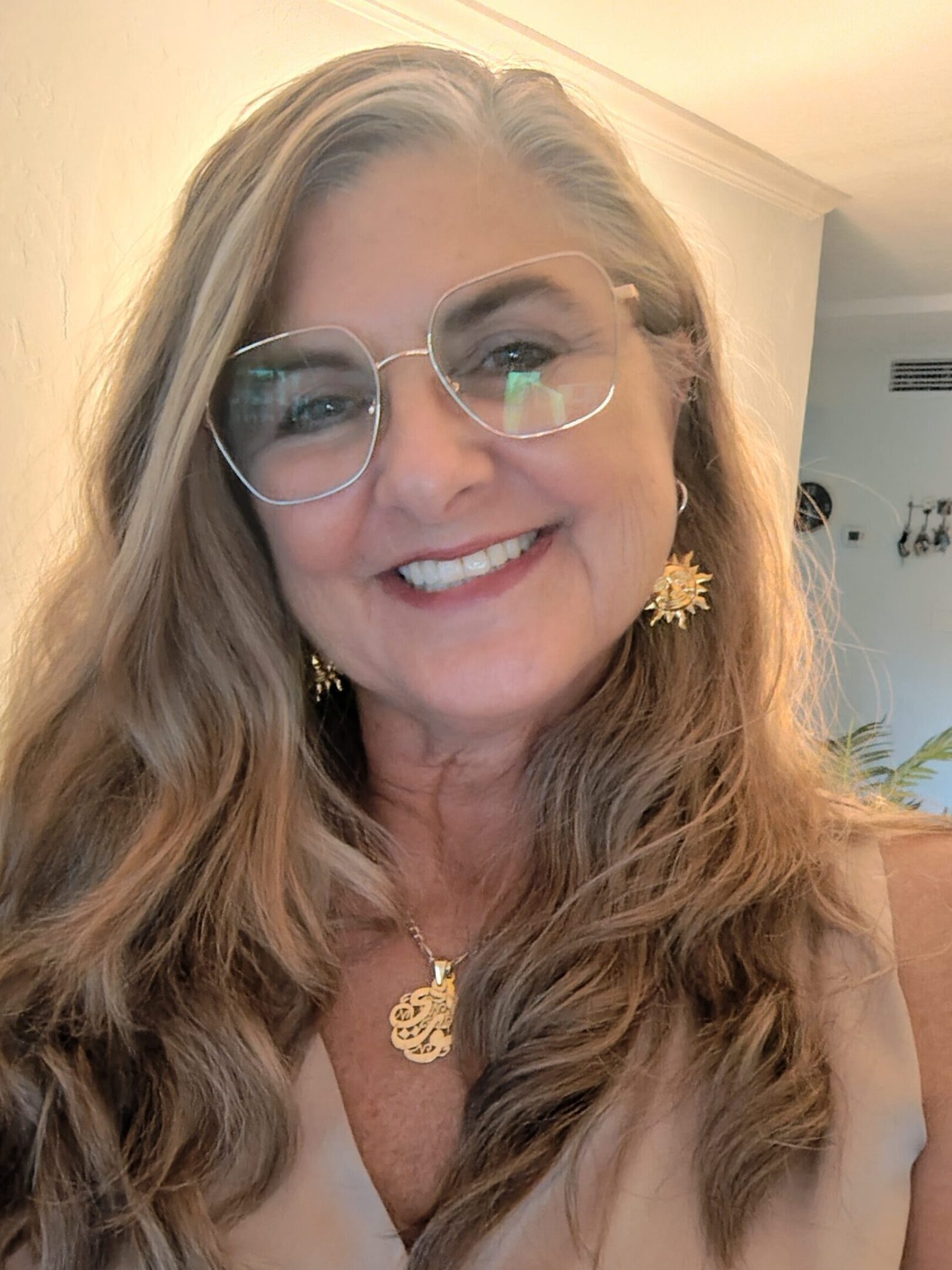 Smiling woman with glasses and gold jewelry