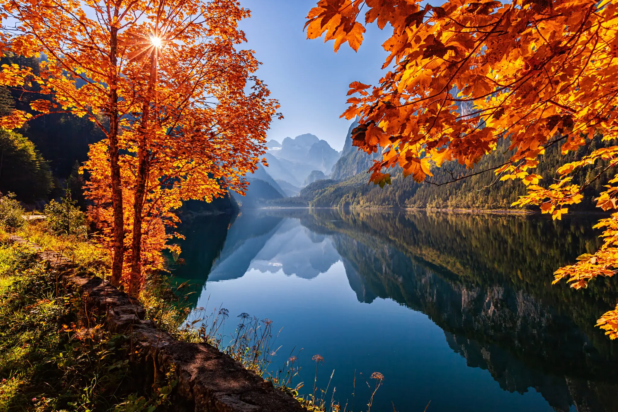 Autumn leaves framing mountain lake reflection