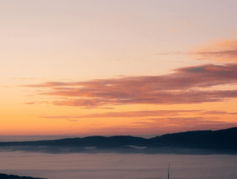 Sunset over foggy valley and distant hills