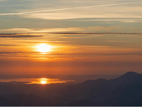Golden sunset over mountains and reflective water